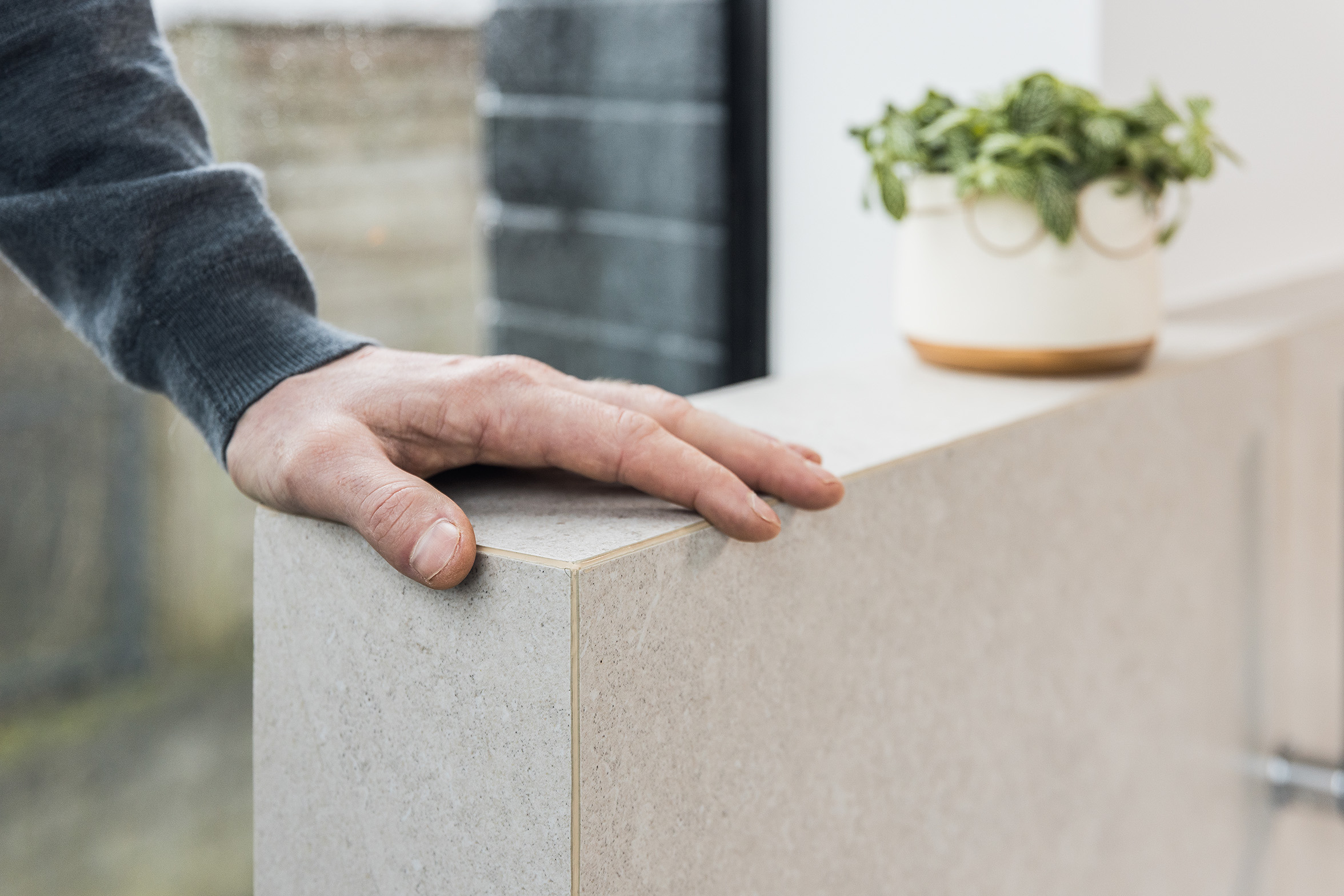 Hand inspecteert nette en afgewerkte tegelrand in woningrenovatie project