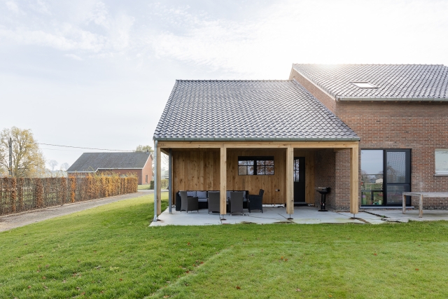 Moderne woning met overdekt terras, houten afwerking en ruime tuin in landelijke omgeving