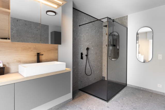 Moderne badkamer met inloopdouche, wastafel en grote spiegel, opgeknapt door De Woonwaaier