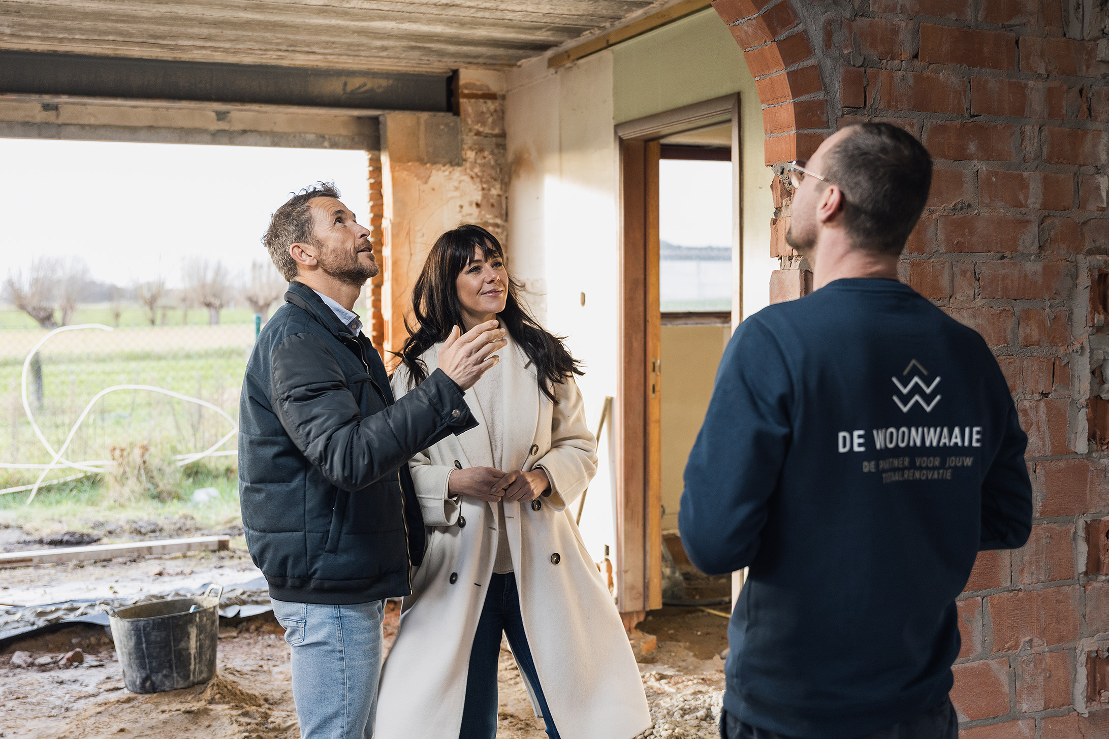 Klanten bespreken renovatieplannen met De Woonwaaier aannemer in een woning onder renovatie